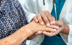 Carer holding elderly's hand